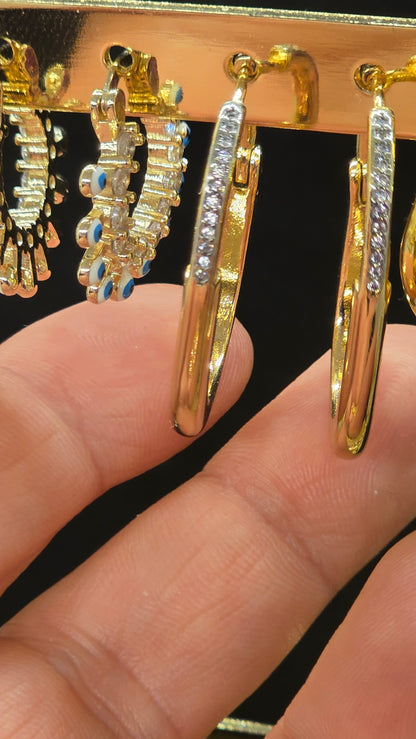 Goldene Creolen in Tropfenform mit Zirkonia-Steinbesatz in der Hand