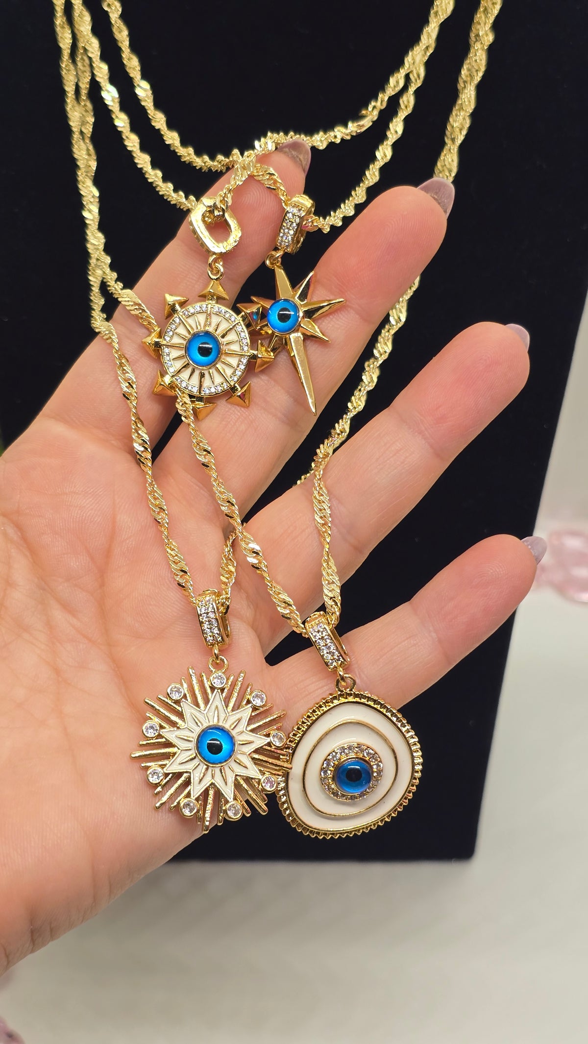 Singapurkette 18K vergoldet mit Evil Eye Anhängern Sonnenstrahl und Oval in der Hand